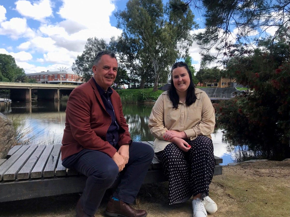 Mayor Cr Dallas Tout and Emma Corbett sitting on seat next to Wollundry Lagoon