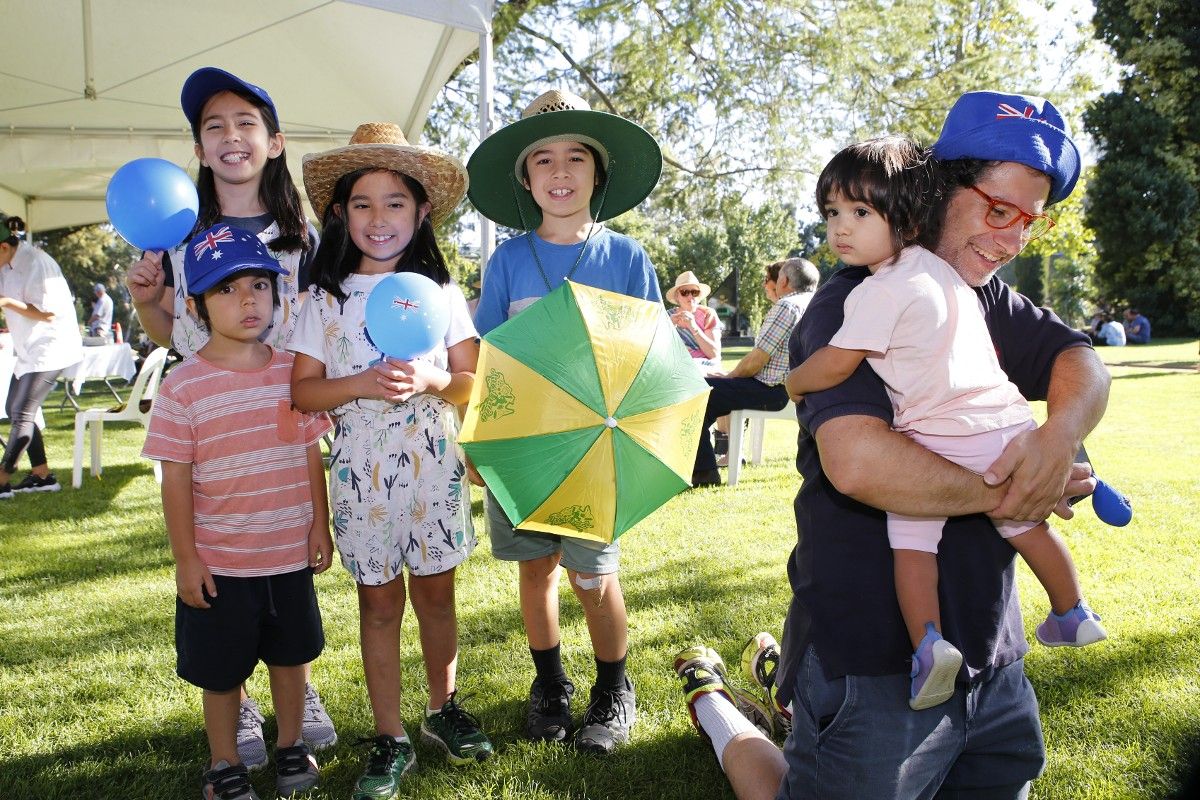 Family of four children and father wearing Australia hats etc