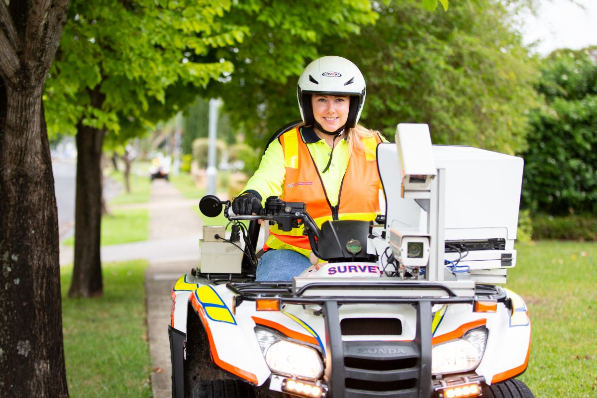 A woman operating a modified quadbike doing footpath inspections. 