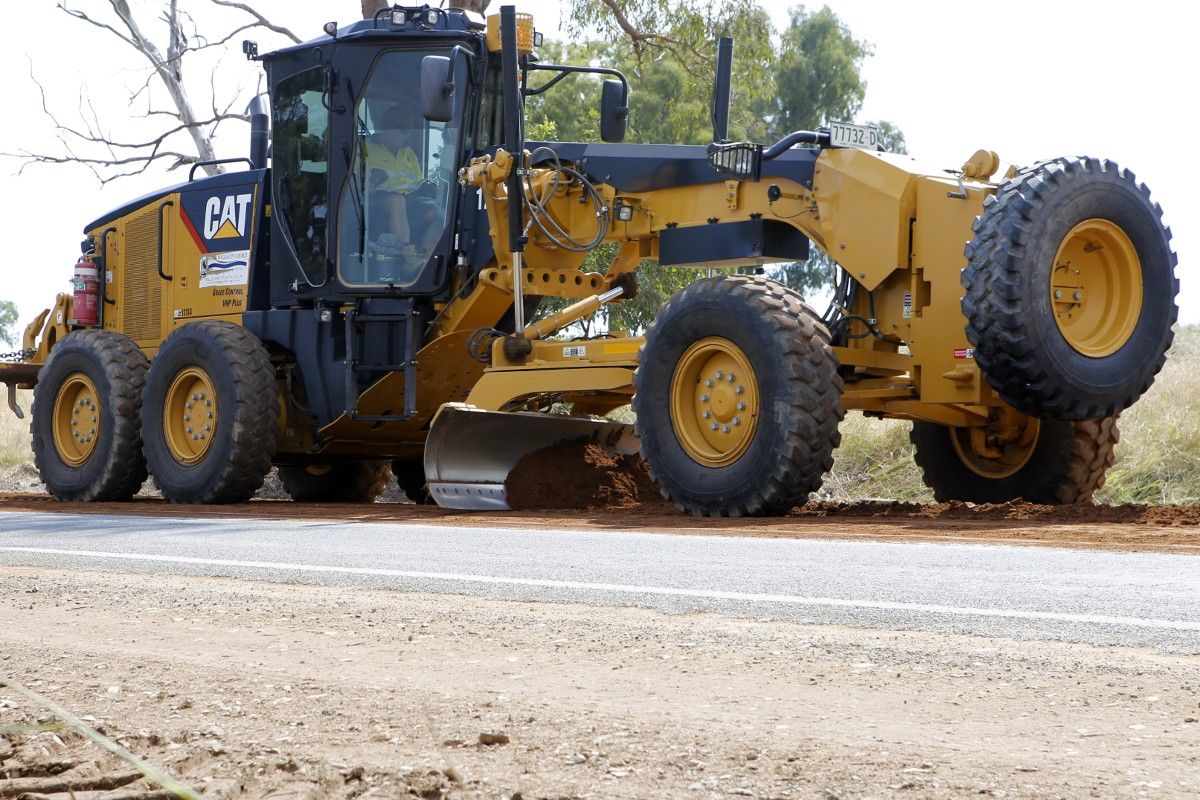 Grader working on unsealed road surface.