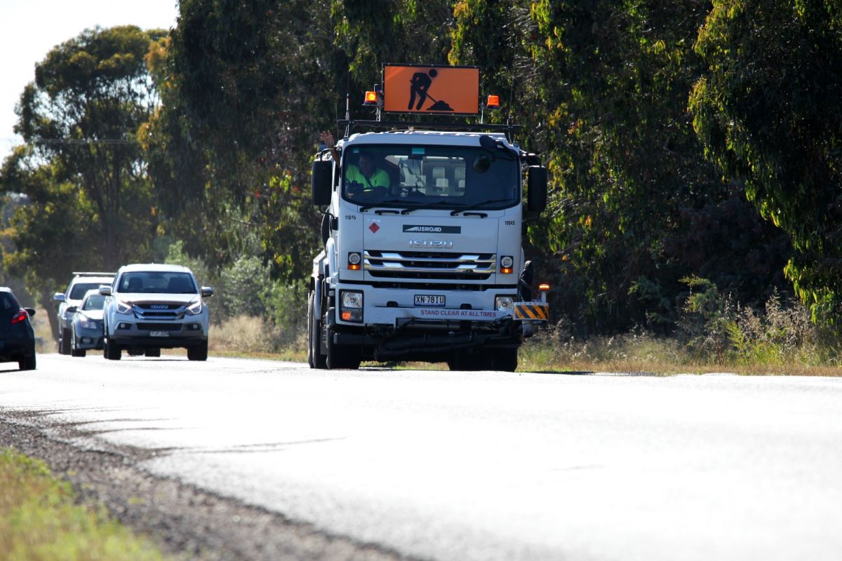 Jet patching truck on road with vehicles behind it