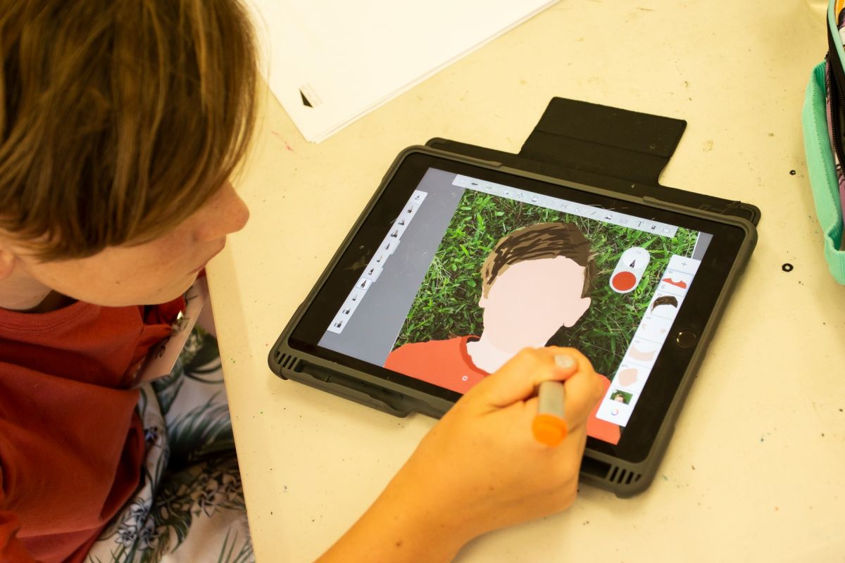 Young boy creating digital self portrait on tablet