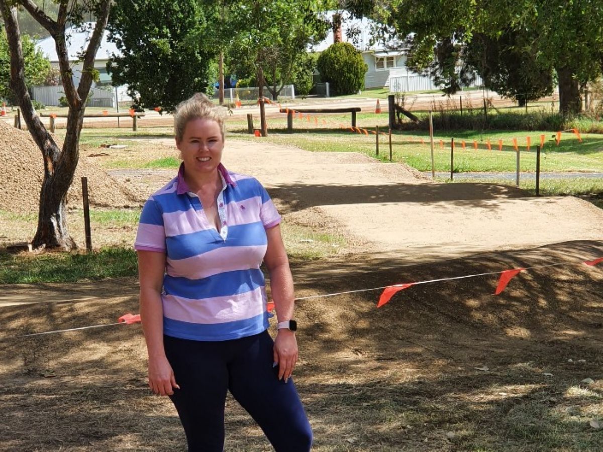 Woman standing in a park in front of a track