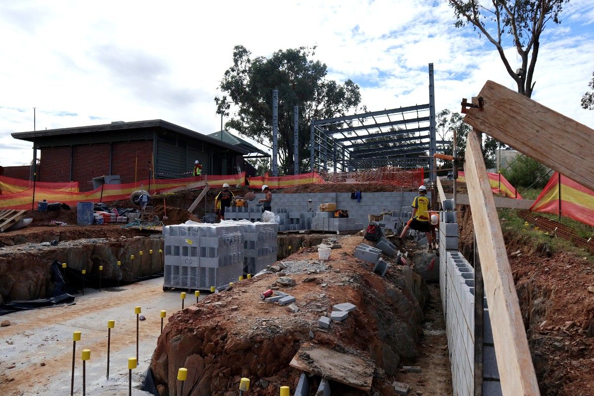 Construction site with labourers and building frames, brickwork