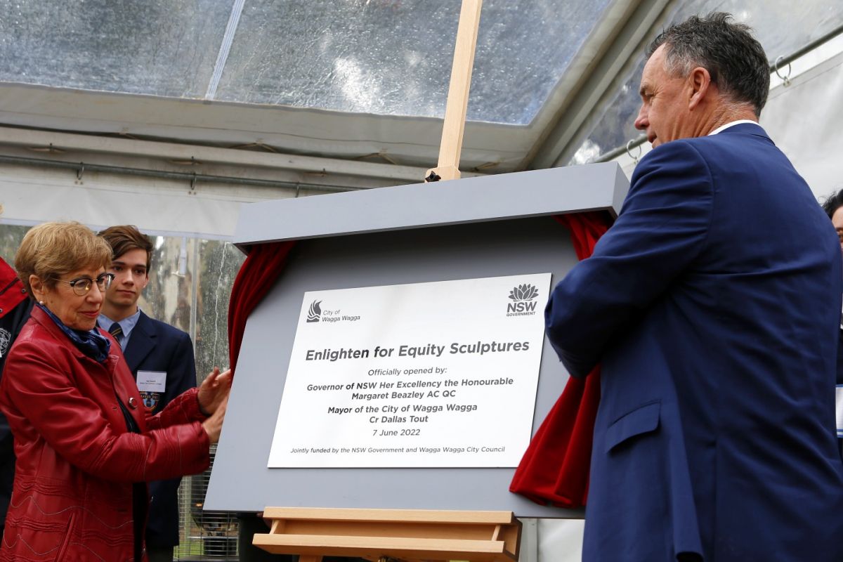 Woman and man unveiling plaque