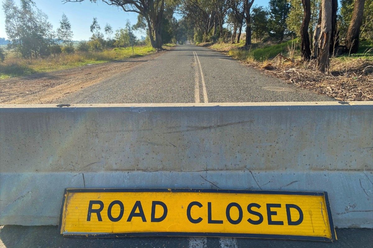 Road closed sign and concrete barrier on a road