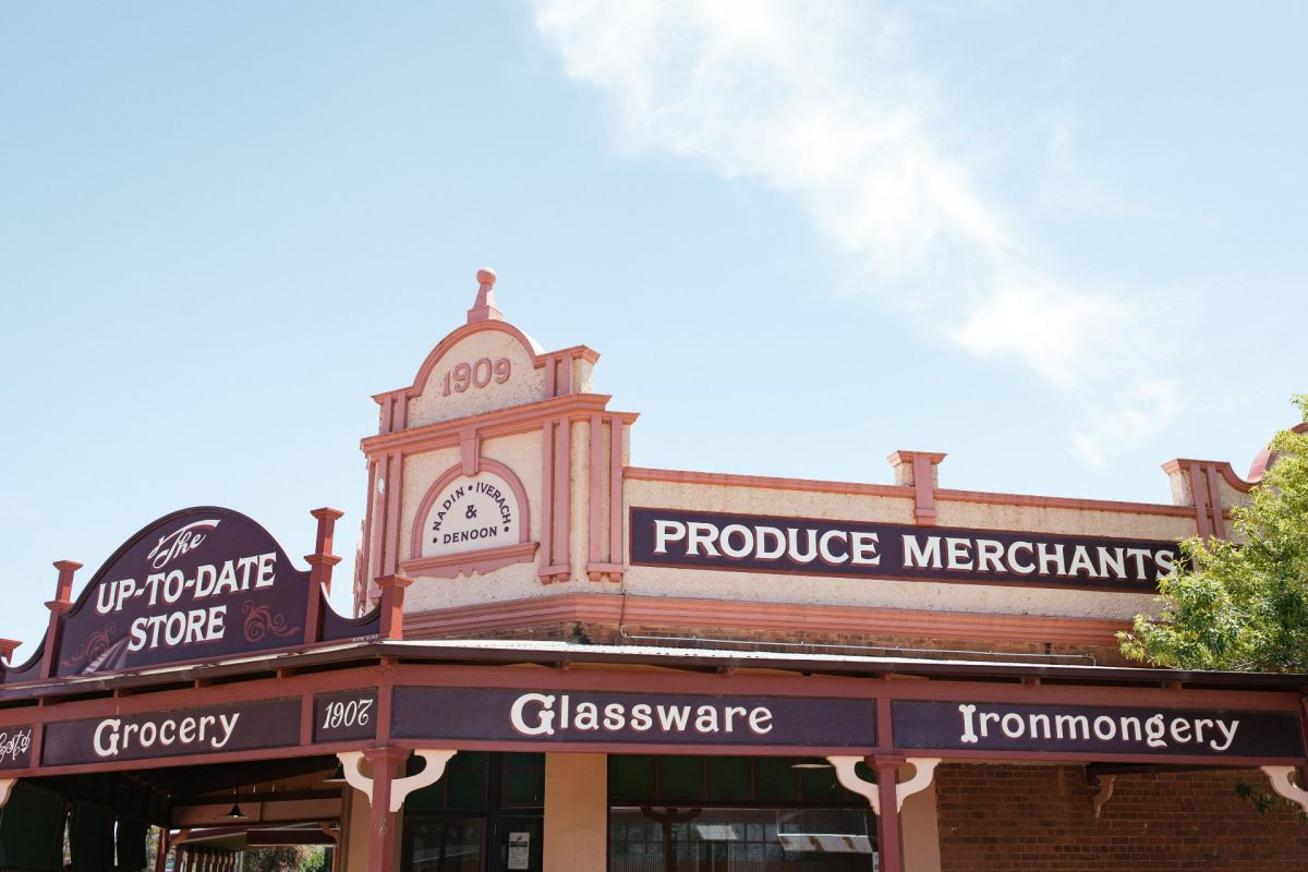 Exterior view of heritage building, with old fashioned signs for groceries and glassware on exterior of Up To Date Store in Coolamon