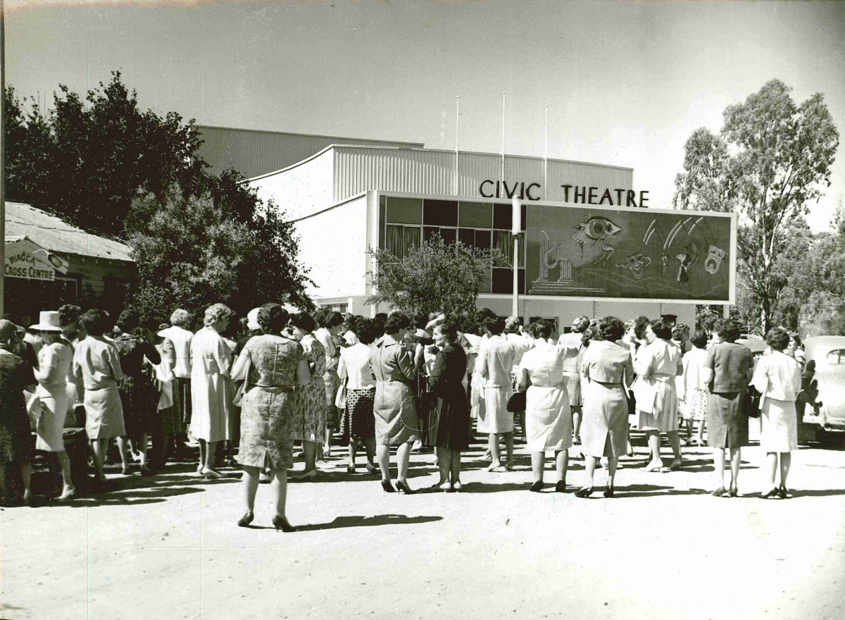 Black and white image of people crowded around the theatre on day of opening.