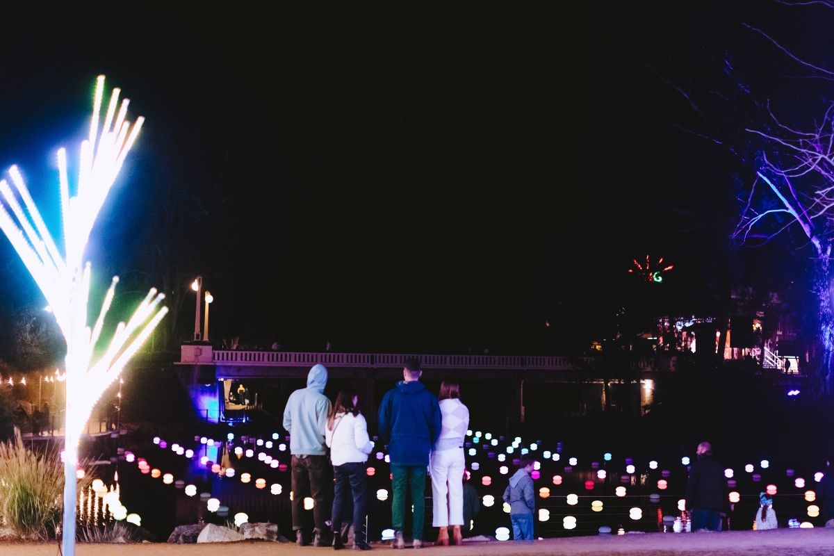 Family looking at a large-scale light display at night time.