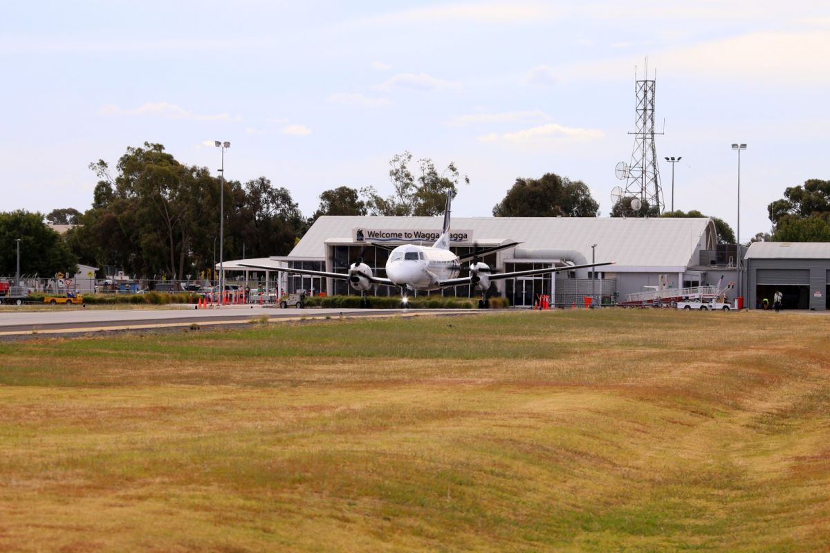 Commercial aircraft taxiing away from the Wagga Wagga Airport terminal apron.