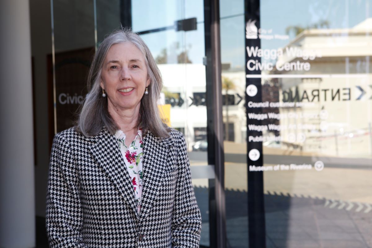 A woman in a tweed blazer standing in front of the Wagga Wagga City Council building.