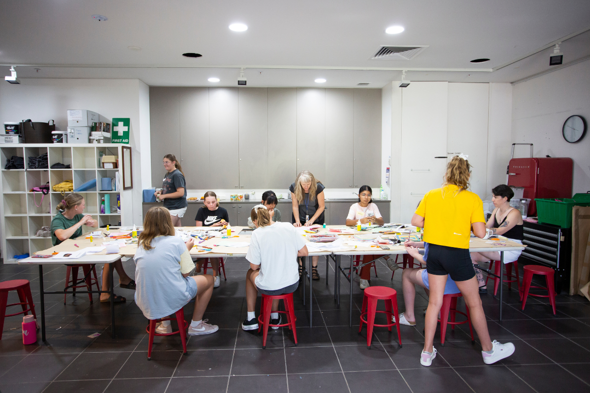 An inside shot of the workshop space where multiple young people are working with art supplies.