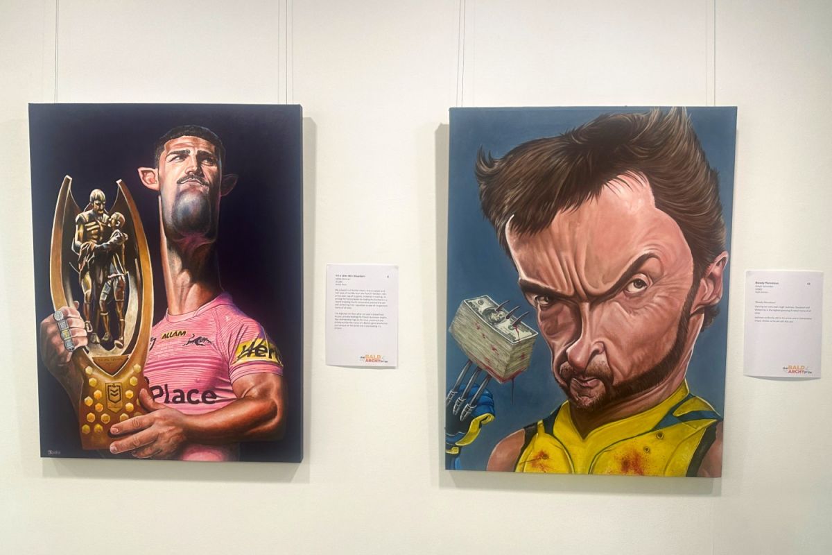 Two portraits hung on a gallery wall, one featuring Panthers half-back Nathan Cleary holding the NRL Premiership trophy and the other with Hugh Jackman as Wolverine with a pile of US dollars jammed on his claw.