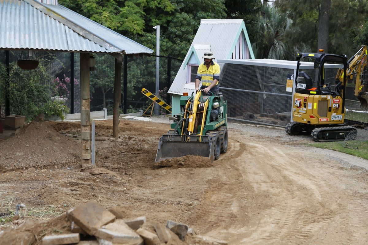 A council staff member operates a bulldozer machine.