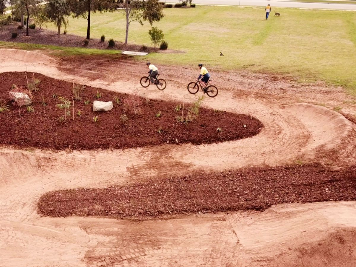 compacted earth bike jump track, two cyclist