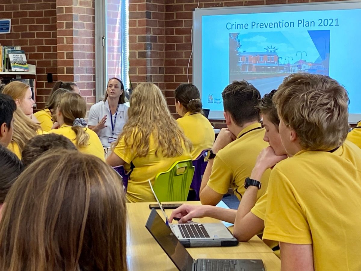 A woman speaks to a group of high school students