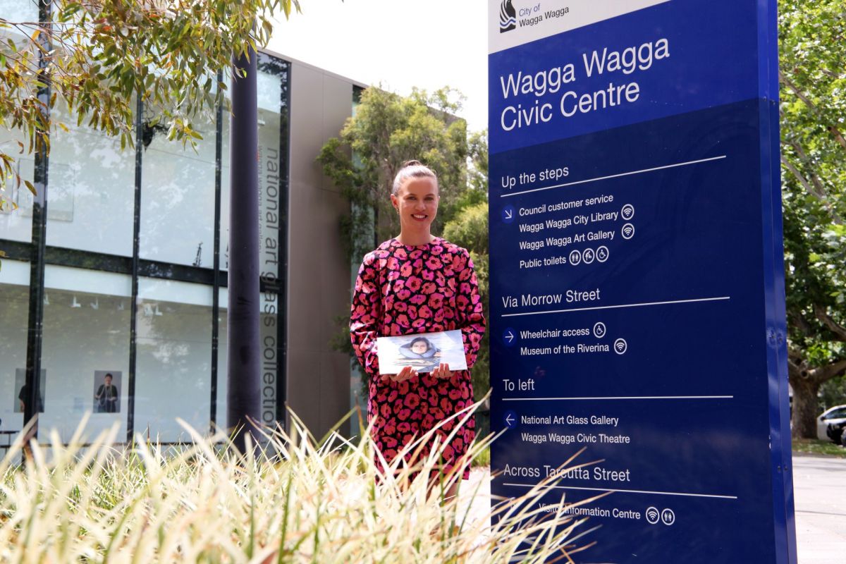 Woman standing next to sign about accessing council building