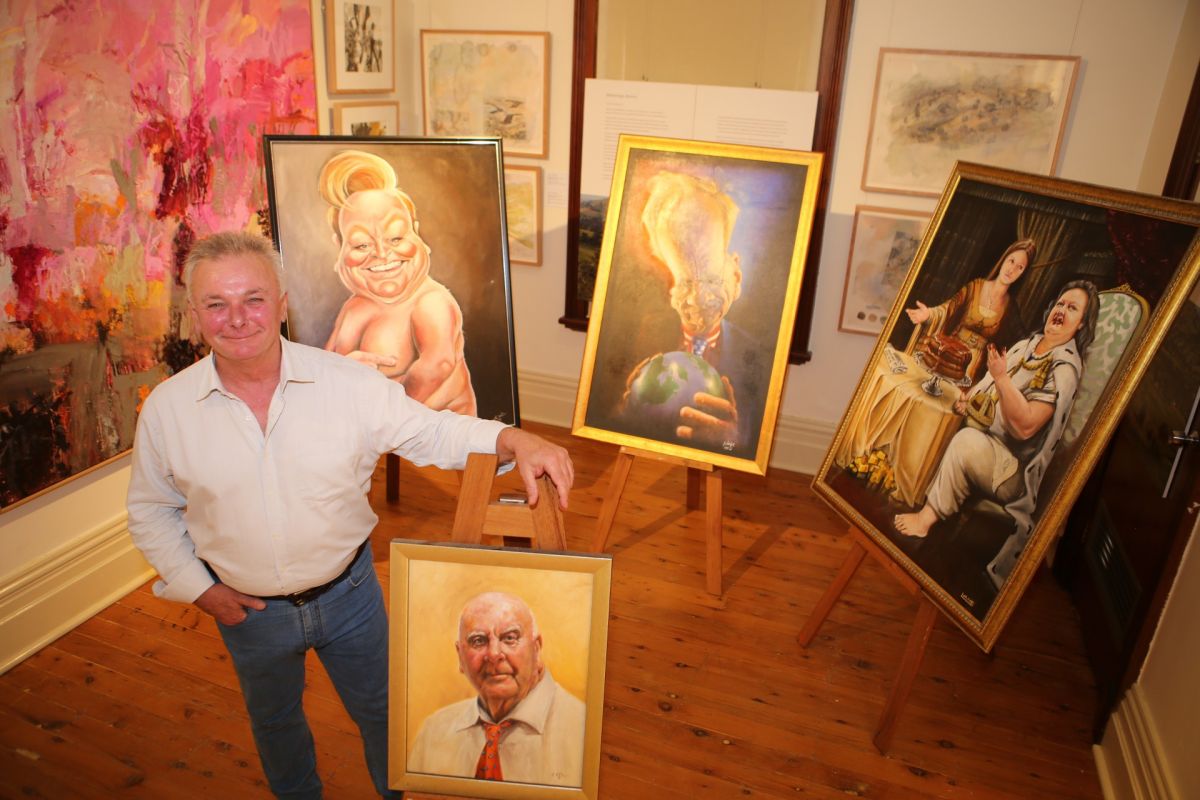 Museum manager standing beside portraits