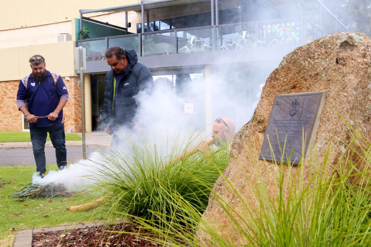 Three First Nations men conducting smoking ceremony