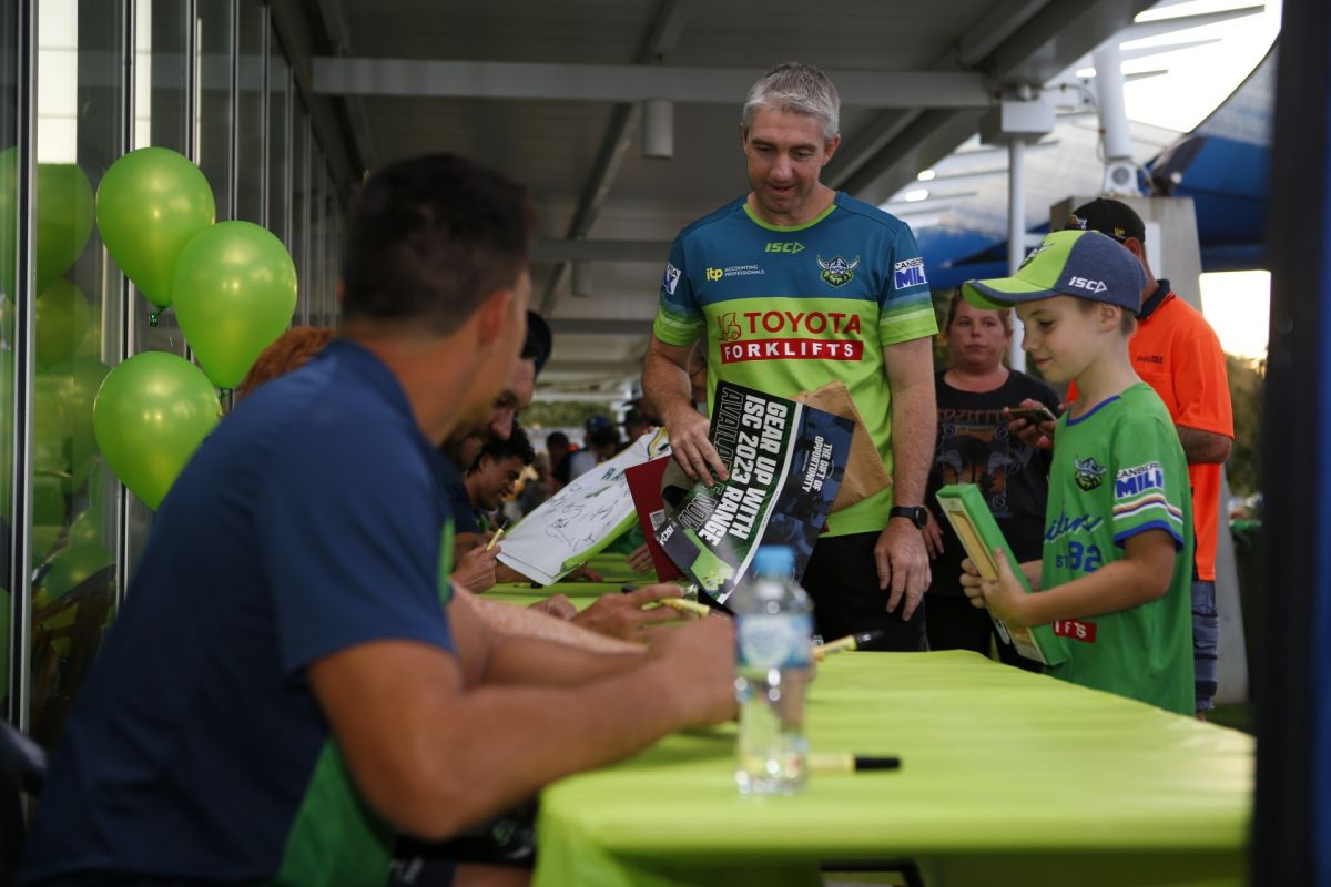 man and his son get merchandise signed by Raiders players