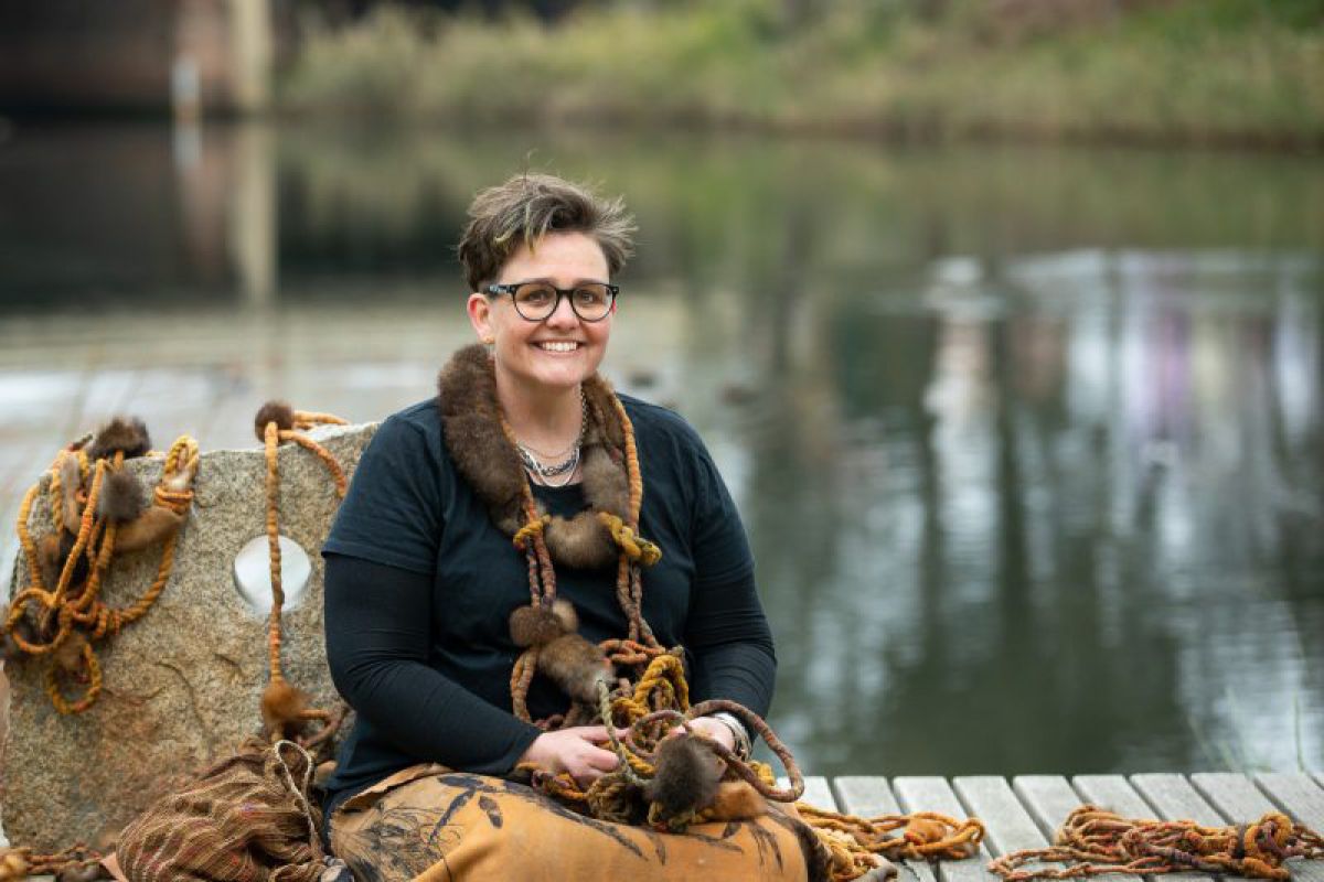 Woman sitting on bench with lagoon in background