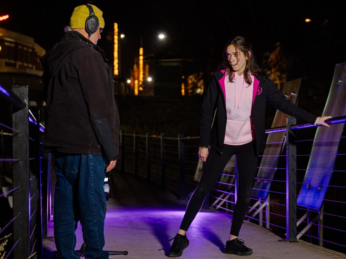 Young female dancer and artist on boardwalk, recording dance movements