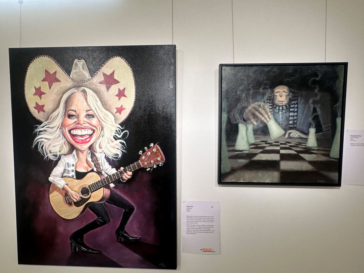 Two portraits hung on a gallery wall, one featuring a laughing blonde woman, Beccy Cole, wearing an oversized cowboy hat and strumming a guitar, and the other with Peter Dutton sitting in at an oversized chessboard, moving pieces that look like nuclear power plant cooling towers.