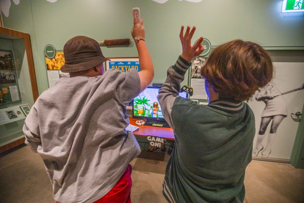 Two boys playing a Nintendo Wii at the Museum of the Riverina. 