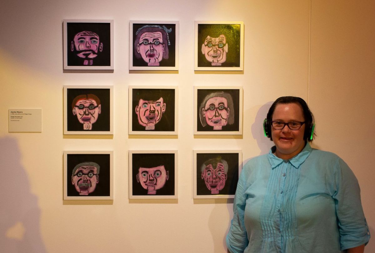 Woman standing next to series of artworks