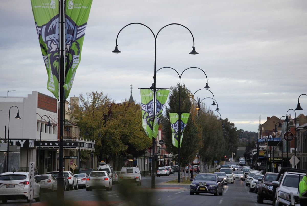 cars driving up flag lined street