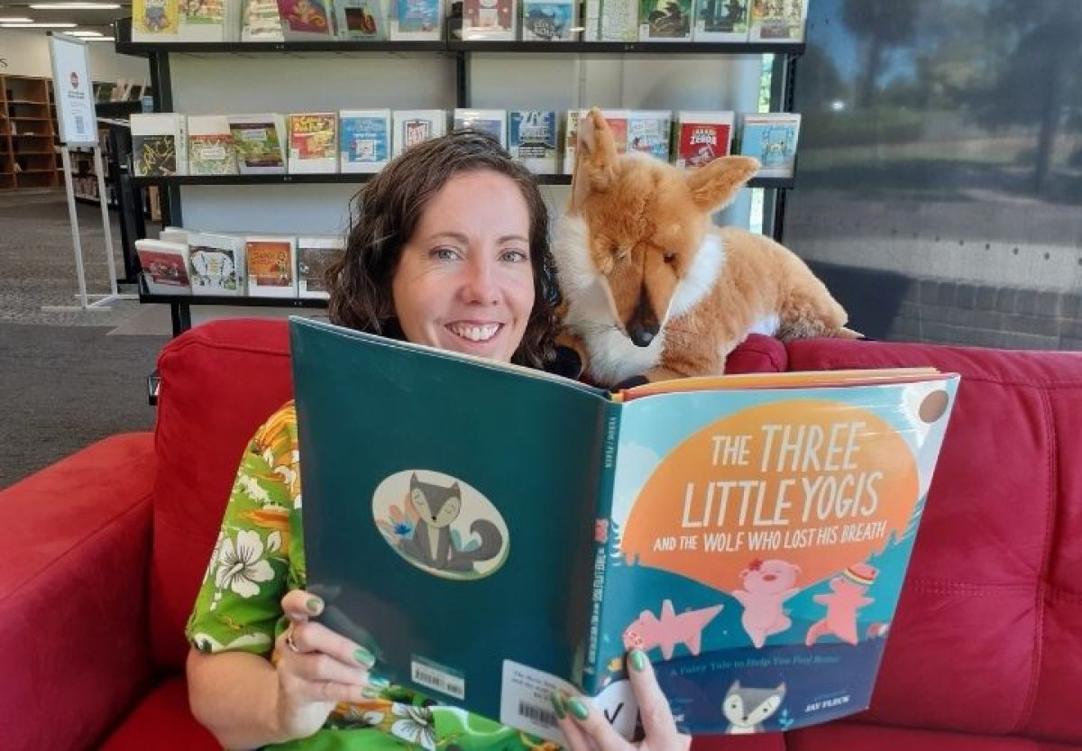 Woman sitting in library reading a children's book