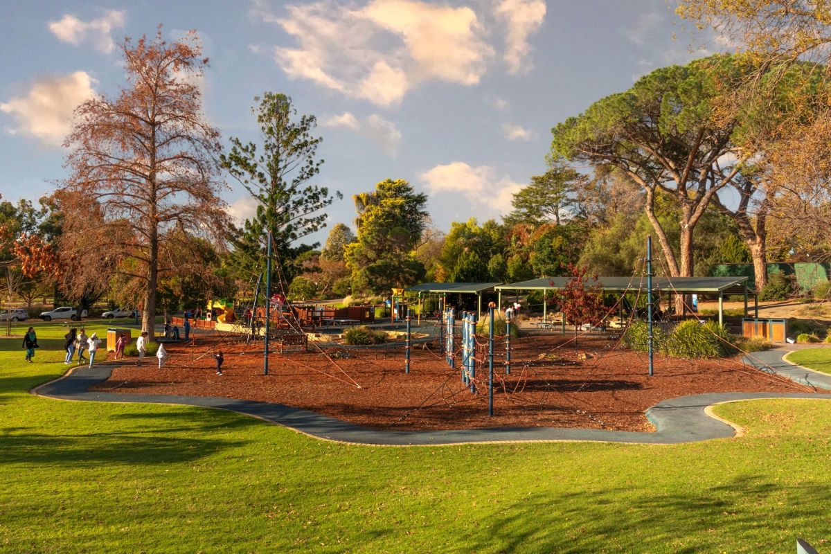 Playground in park with young people using play equipment