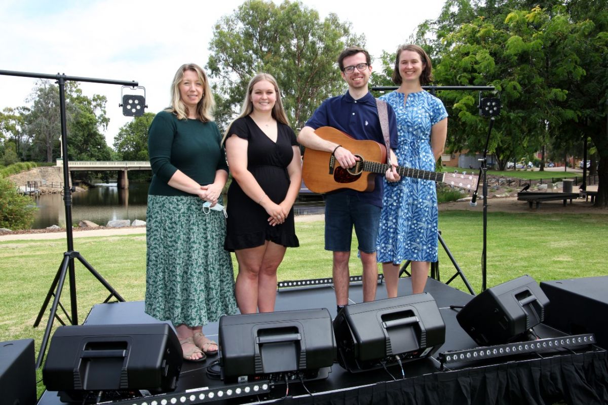 Two council staff with two young musicians, surrounded by music kit