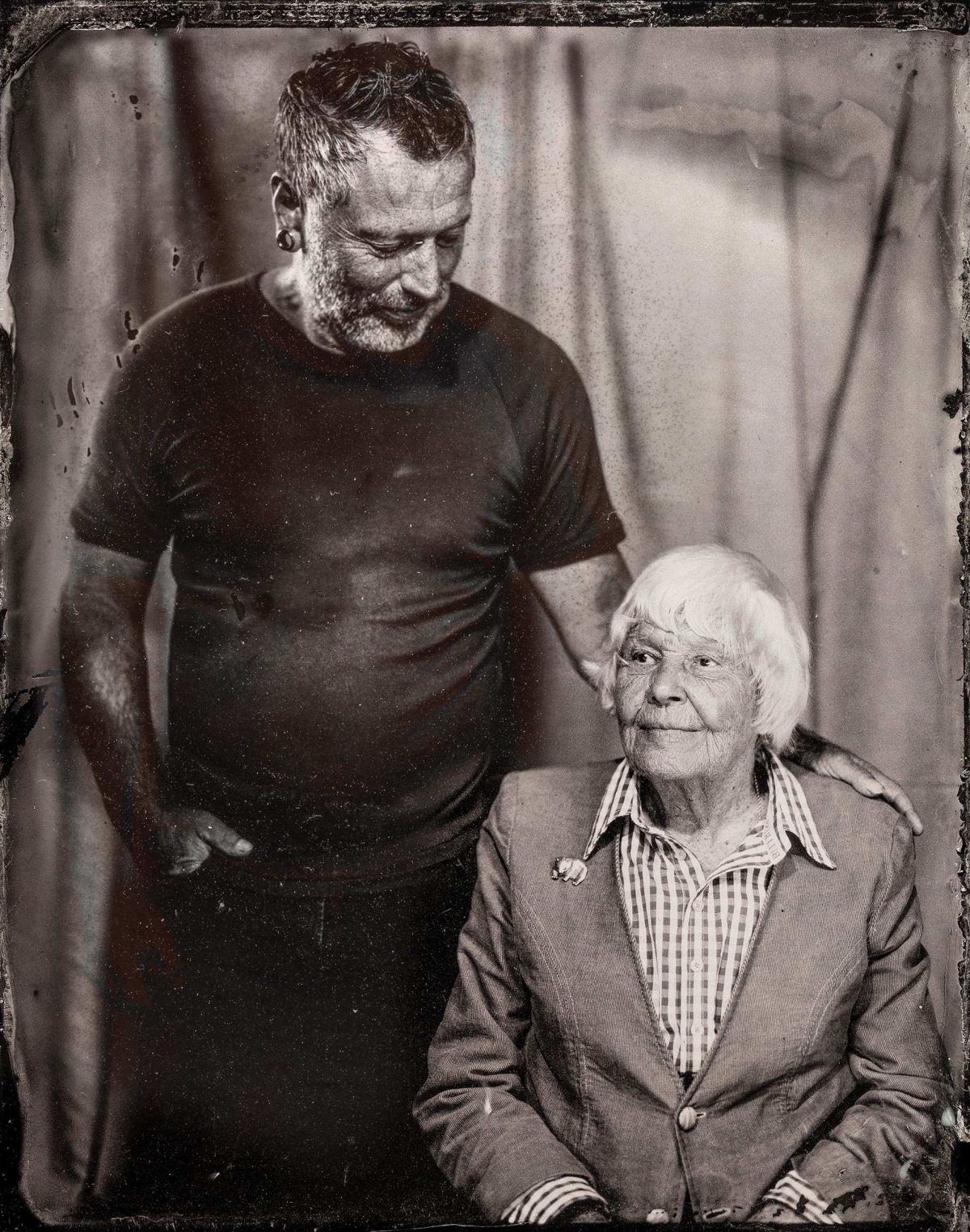 Tintype of man standing next to seated woman