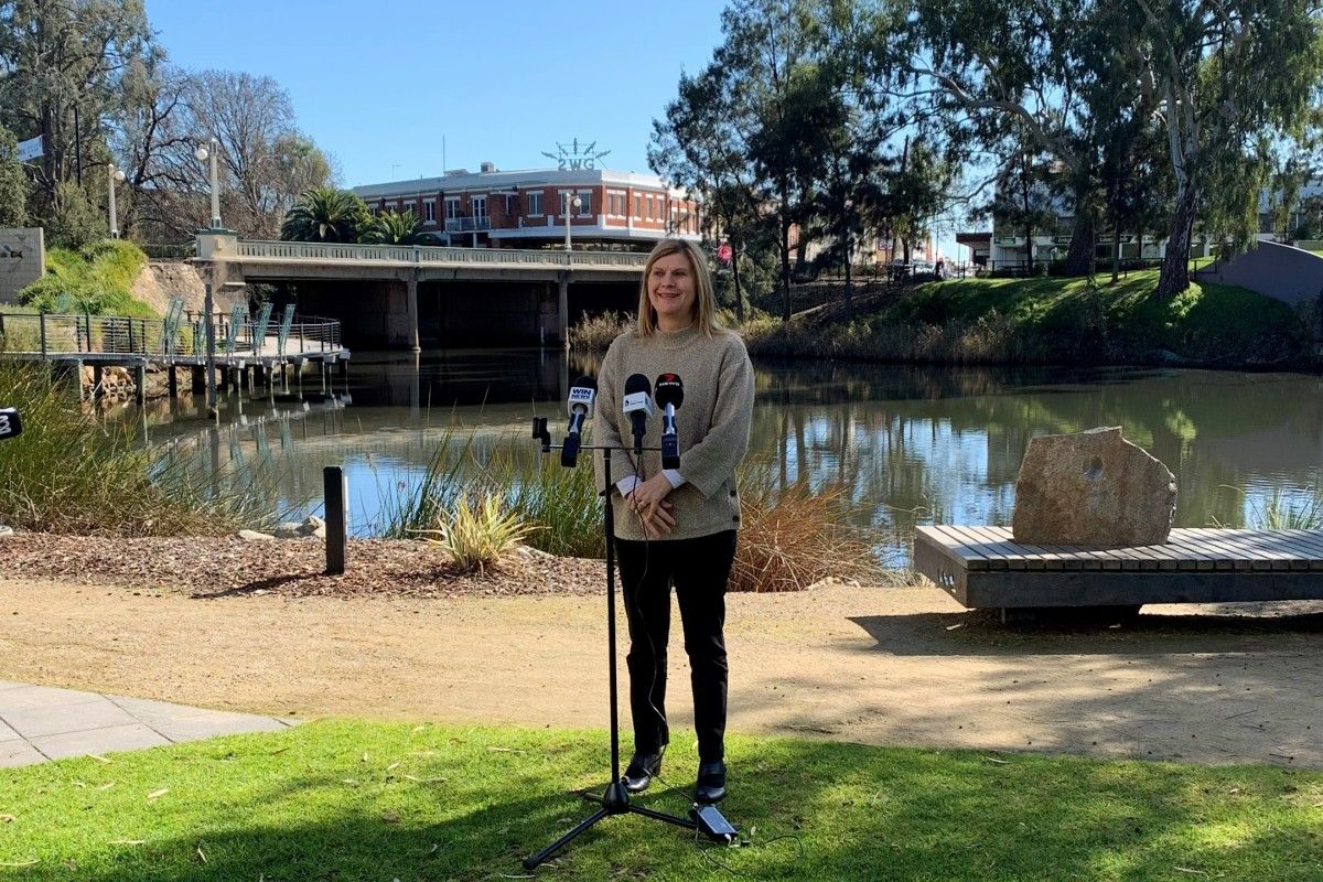 Janice Summerhayes, woman at microphone, lagoon in background