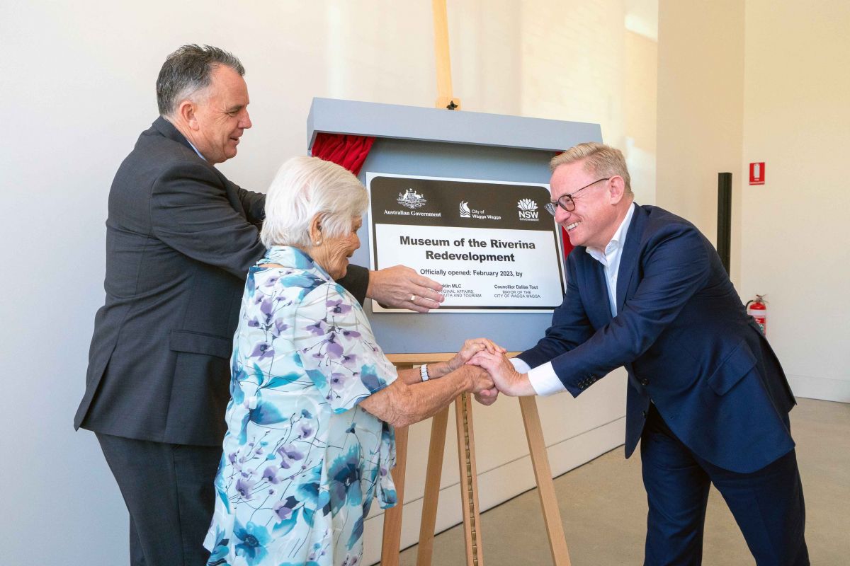 Two men and woman unveil plaque