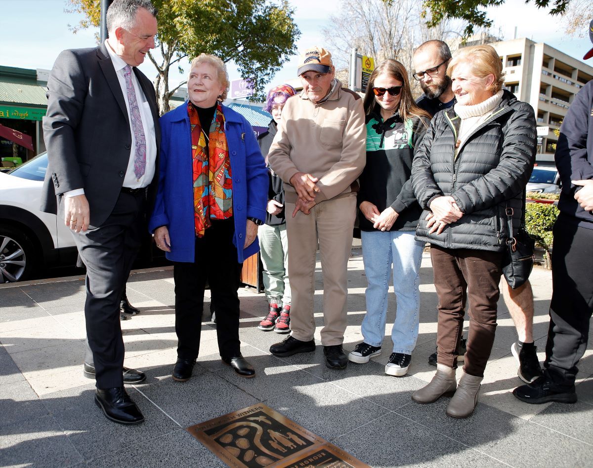 a group of people standing around a recently unveiled plaque
