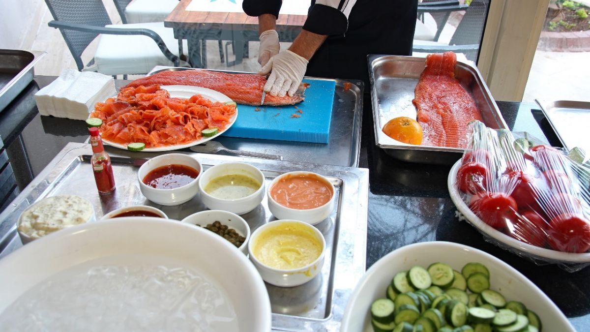 Fish, vegetables and condiments being prepared in commercial kitchen