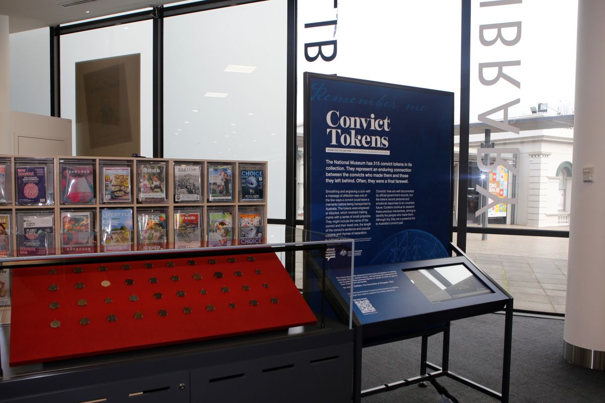 Convict Tokens display at library including class cabinet and interactive screen.