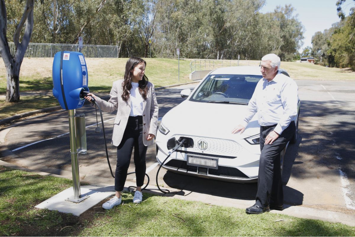  Destination and Events Coordinator Kimberly Parker (left) and Manager Environment & Regulatory Services Mark Gardiner (right) stand with Council EV and try the new charger at the Visitor Information Centre carpark. 