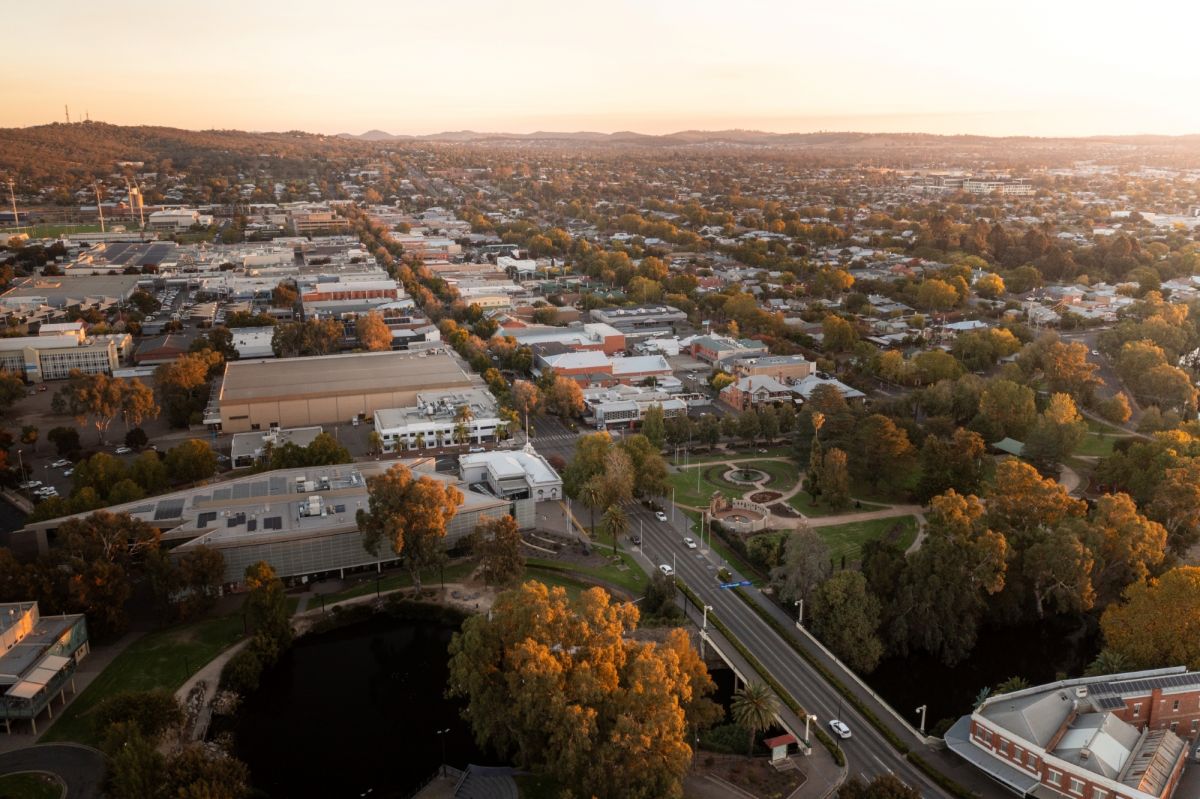 Drone image of Wagga Wagga CBD, showing roads, trees, buildings, and mountains in the distance.