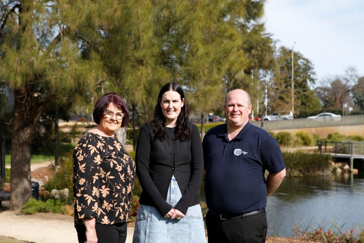 Three people standing outside at the Wollundry Lagoon Precinct, in Wagga Wagga.