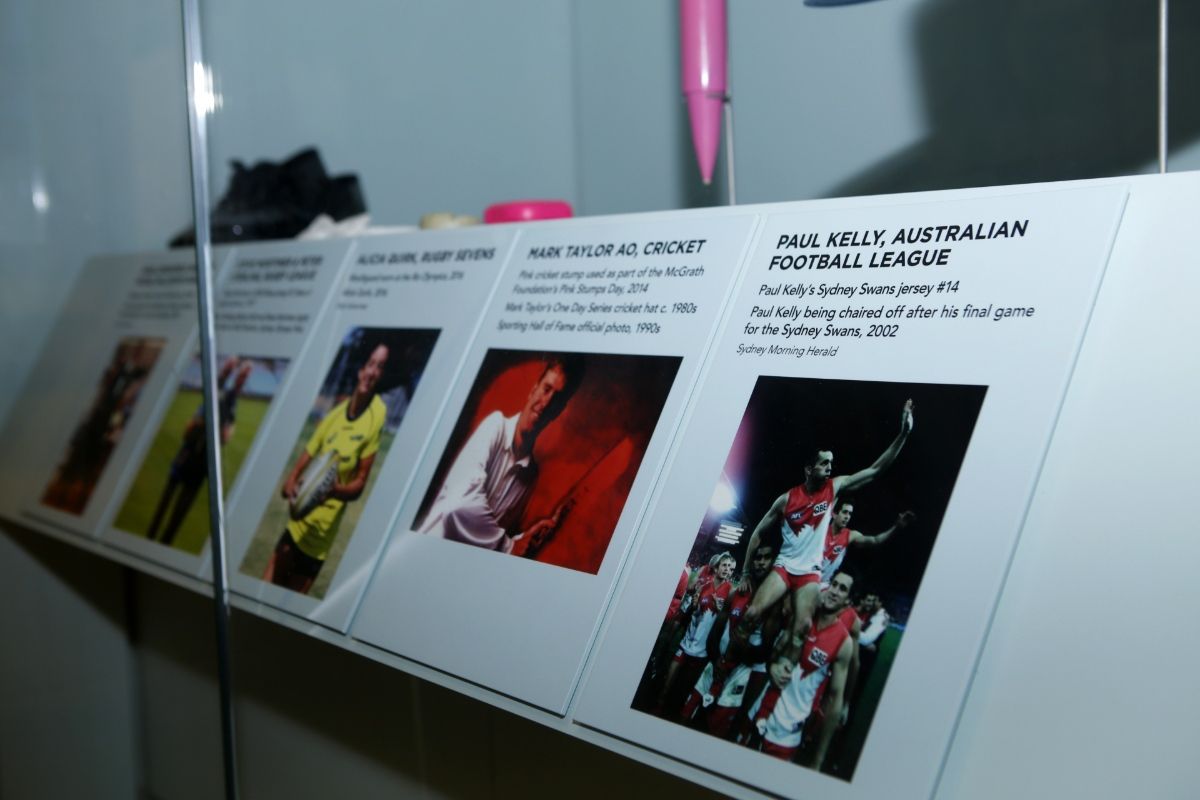 Museum display case with five pictures and a short biography of sporting people, with the names including Paul Kelly and Mark Taylor on the two images in the foreground.