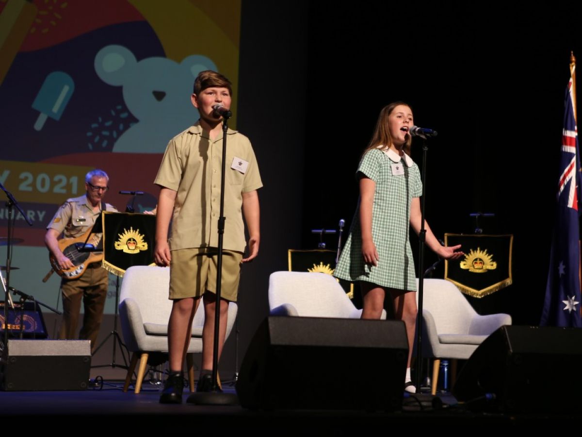 A boy and girl singing on stage.