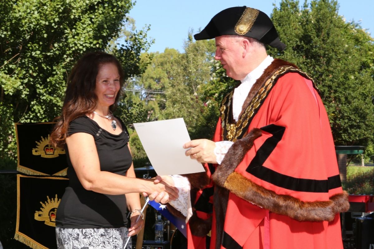 Woman receiving certificate from Mayor in official robes