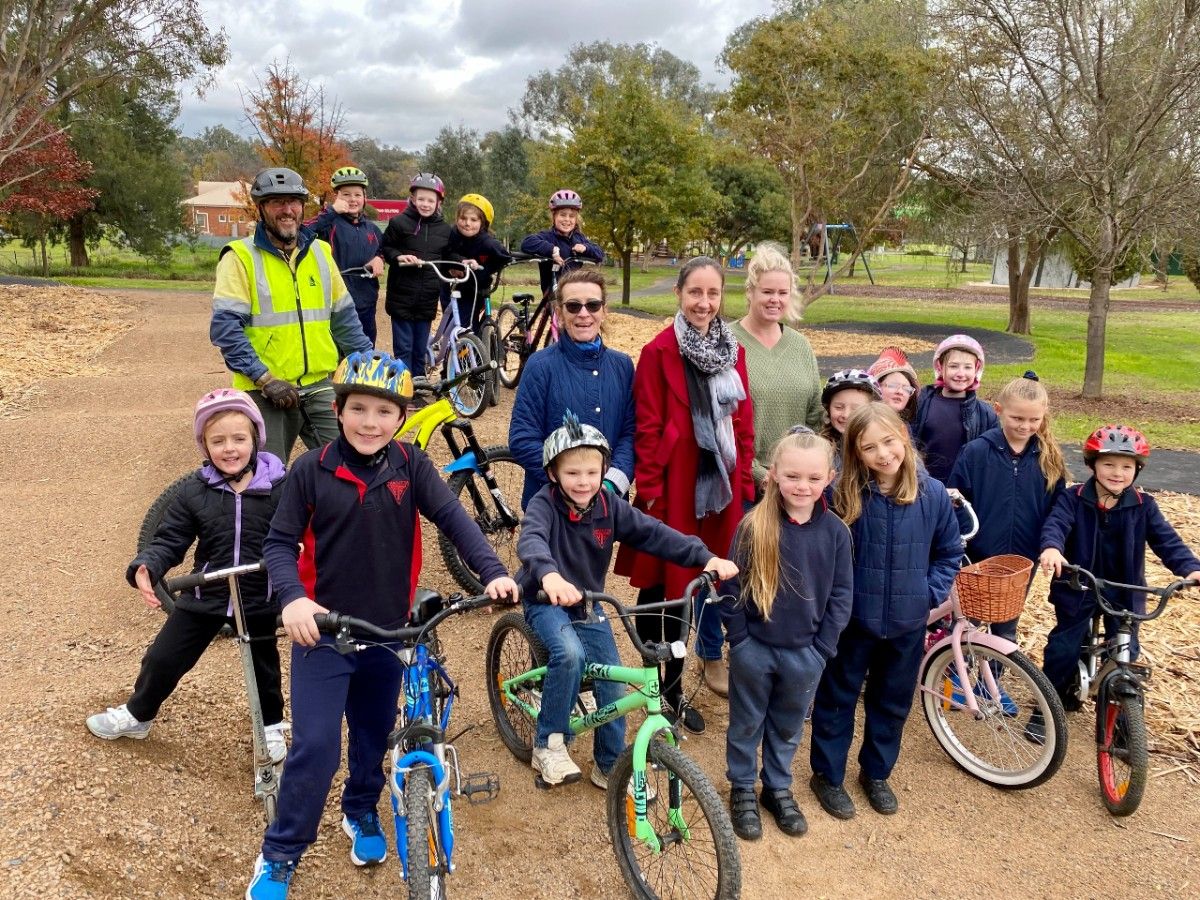 A group of children on bikes with a man and three women