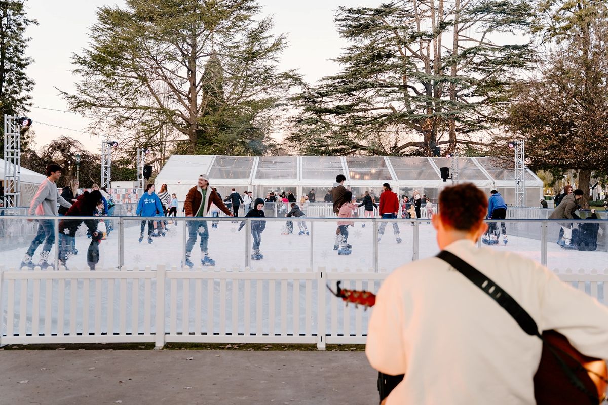 Musician playing in front of ice-skating rink