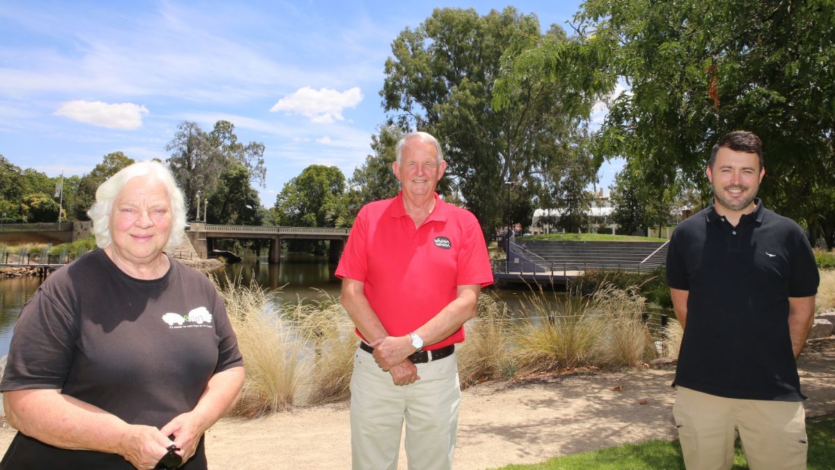 Woman and two men standing in front of lagoon