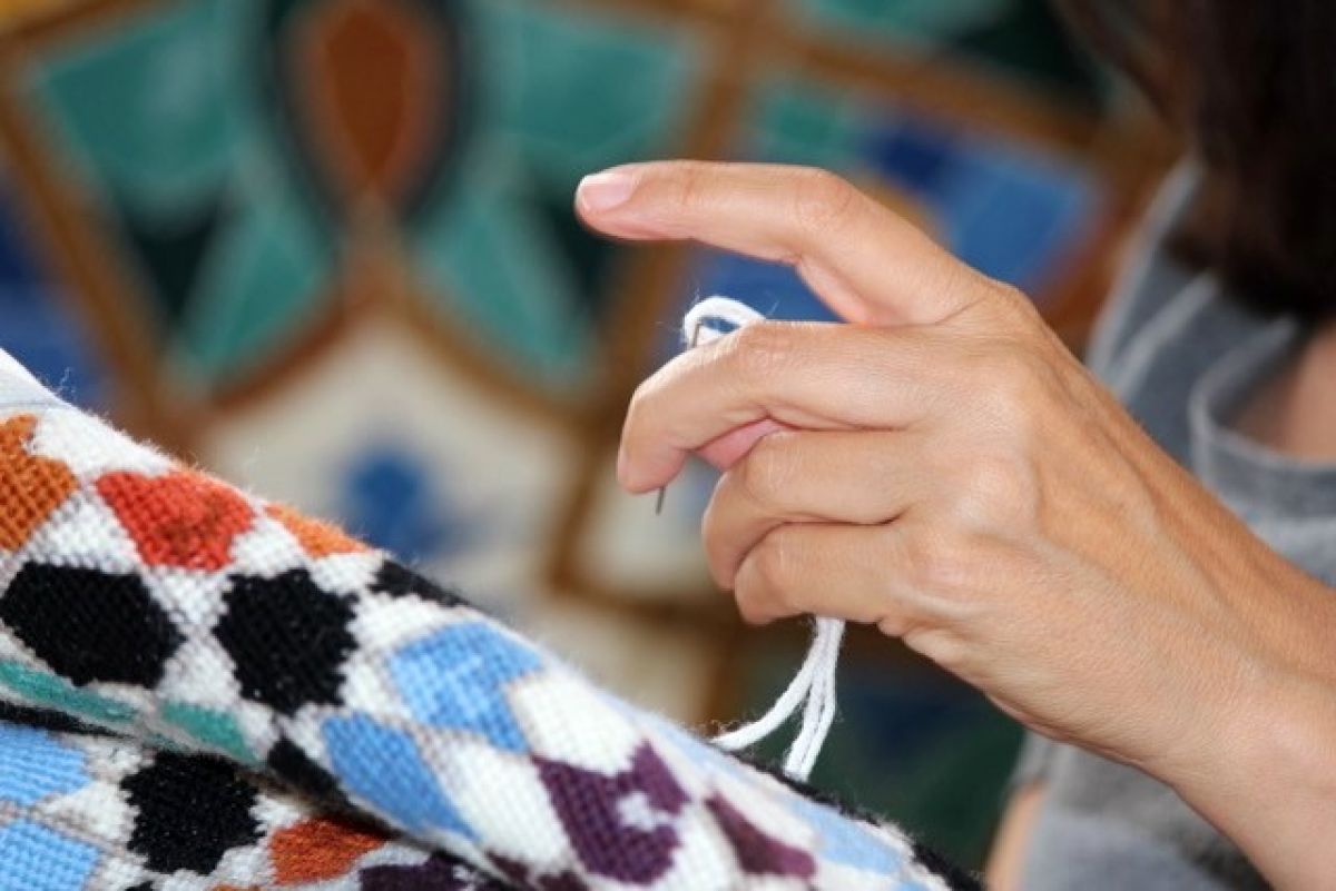 Hands embroidering silk