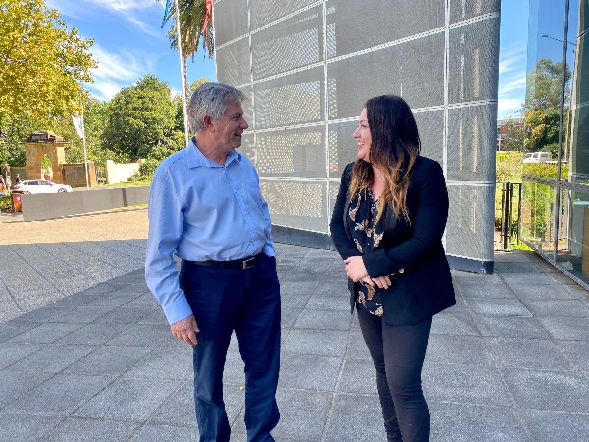 A man and a woman laughing in front of the Wagga Wagga Civic Centre